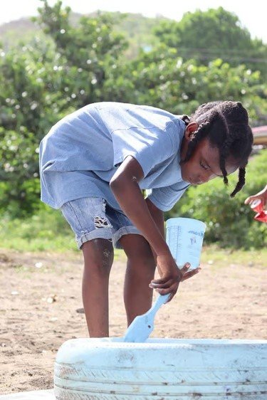 Participant handling discarded plastic material outdoors.