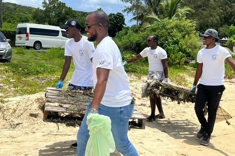 Volunteers removing large wooden debris from the shoreline.