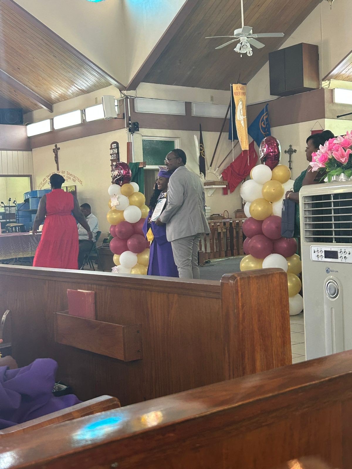 Graduation award presentation; graduate in purple gown with an adult presenter.